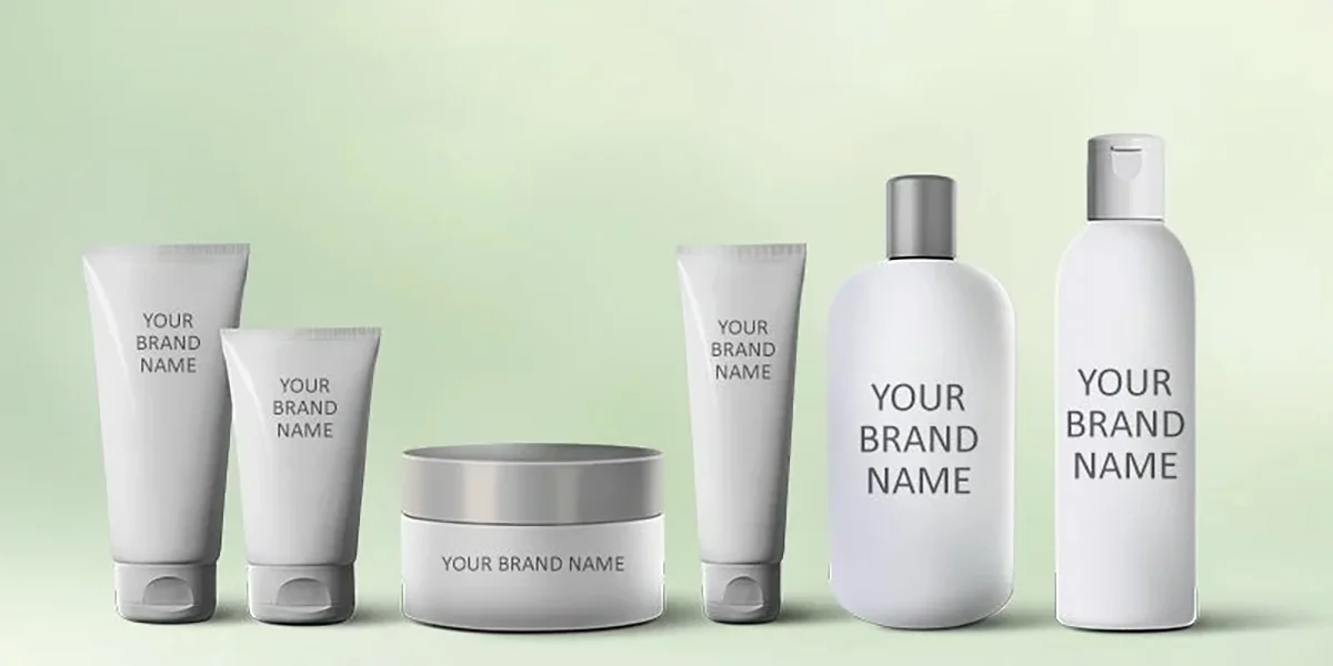 Lineup of blank skincare packaging including tubes, jars, and bottles on a pastel green background, labeled 'Your Brand Name.'